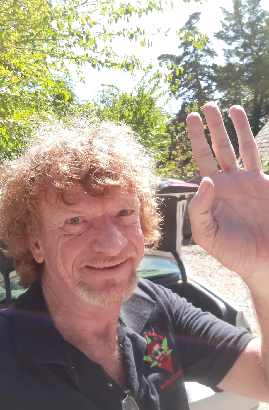 Bill Baker smiling and waving outdoors